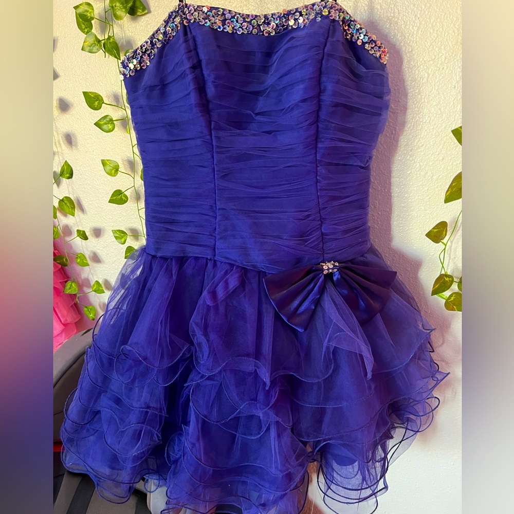 Blue violet strapless dress with bow, ruffles and sequenced trimming.